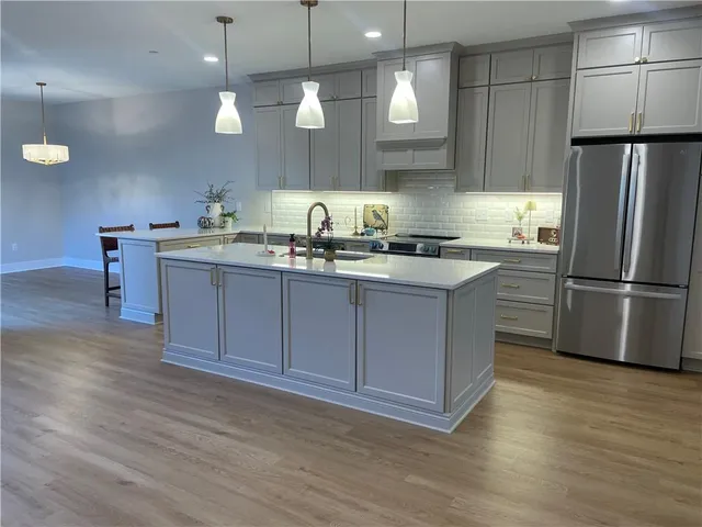 a kitchen with a sink a refrigerator and wooden floor