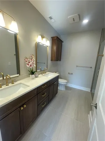 a bathroom with a double vanity sink a toilet and a mirror