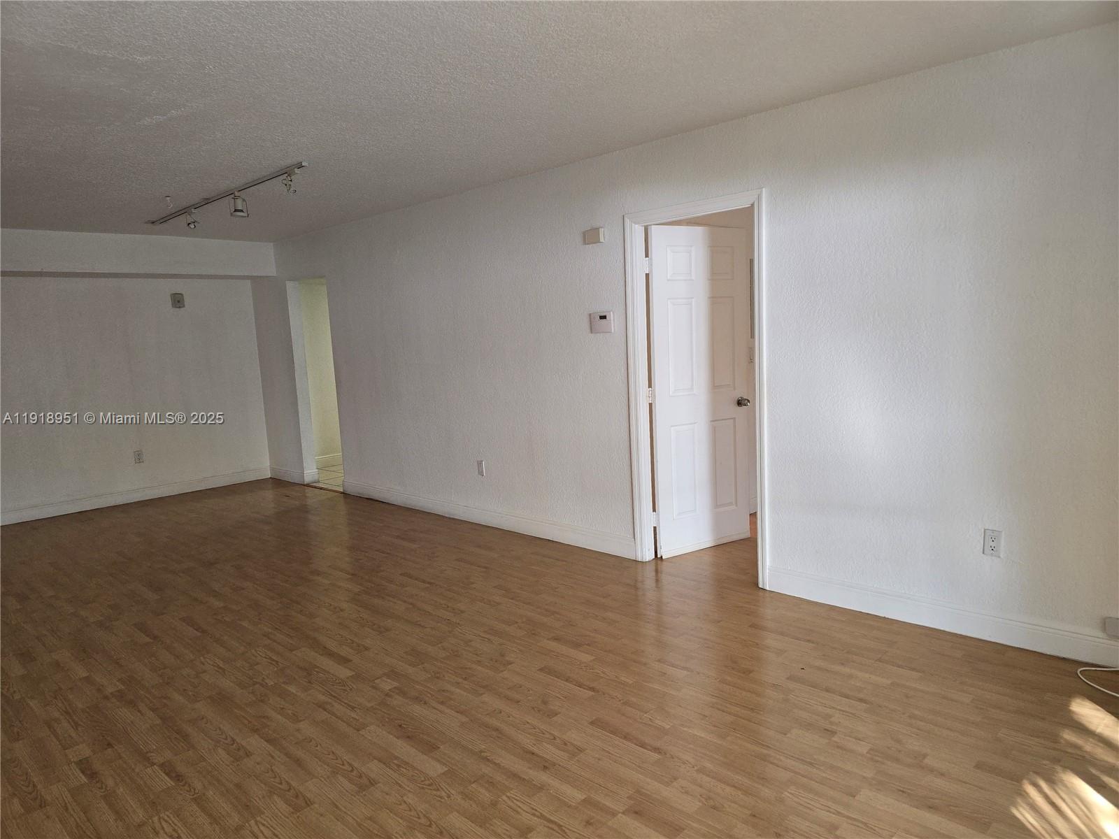 7925 Southwest 104th Street, Unit 201E Miami, FL 33156 - Photo 11 of 30 a view of an empty room with wooden floor and closet