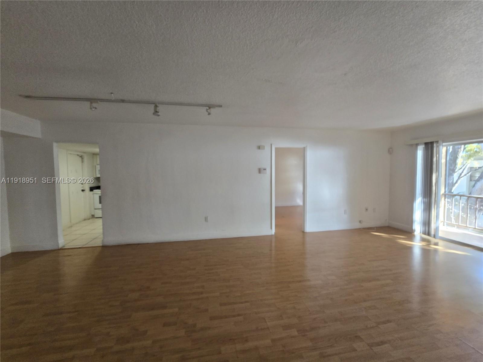 7925 Southwest 104th Street, Unit 201E Miami, FL 33156 - Photo 11 of 32 a view of an empty room with wooden floor and a window