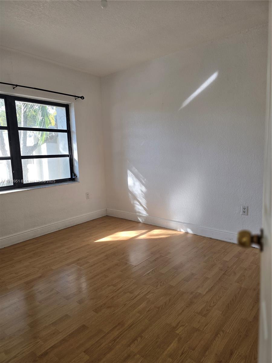 7925 Southwest 104th Street, Unit 201E Miami, FL 33156 - Photo 15 of 30 a view of empty room with wooden floor and fan