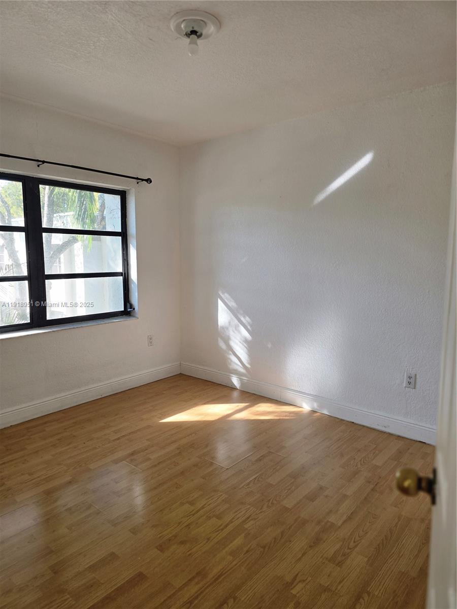7925 Southwest 104th Street, Unit 201E Miami, FL 33156 - Photo 16 of 30 an empty room with wooden floor and windows