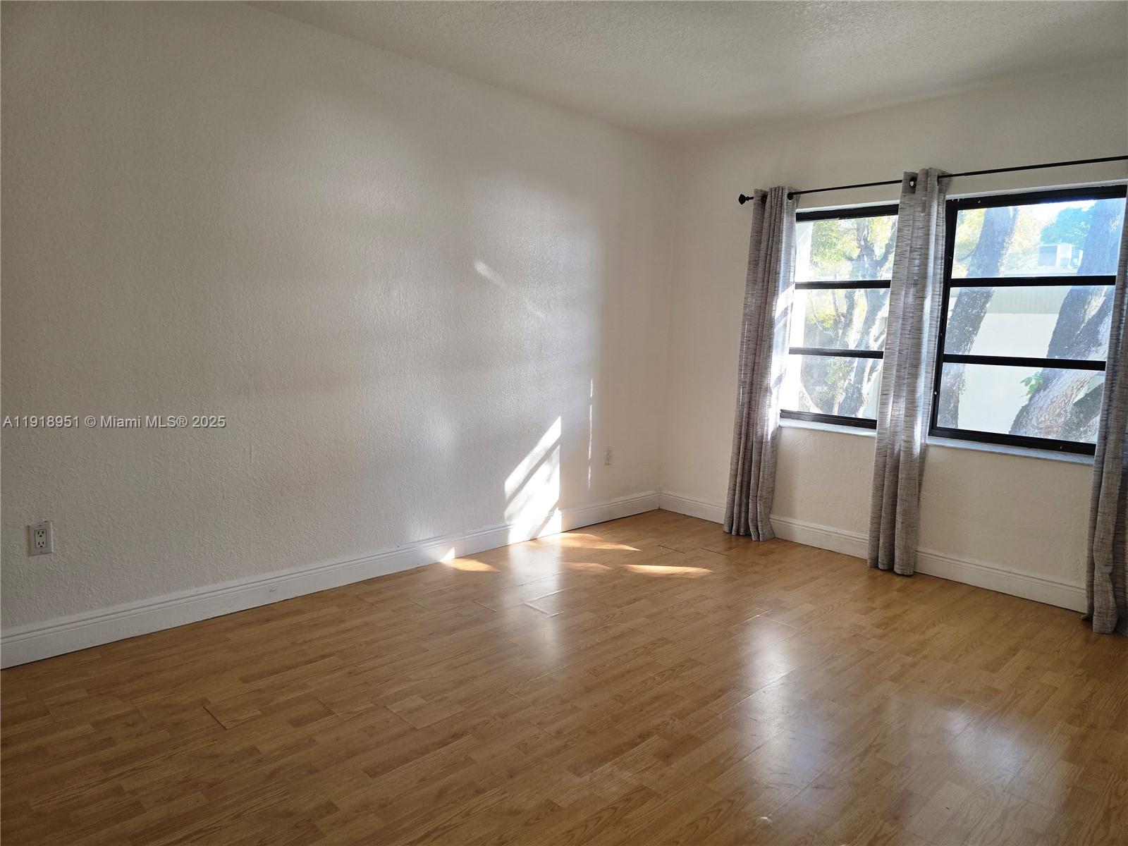 7925 Southwest 104th Street, Unit 201E Miami, FL 33156 - Photo 23 of 30 wooden floor in an empty room with a window
