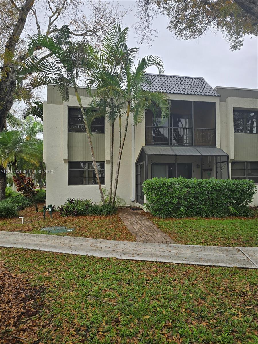 7925 Southwest 104th Street, Unit 201E Miami, FL 33156 - Photo 27 of 32 a front view of a house with garden