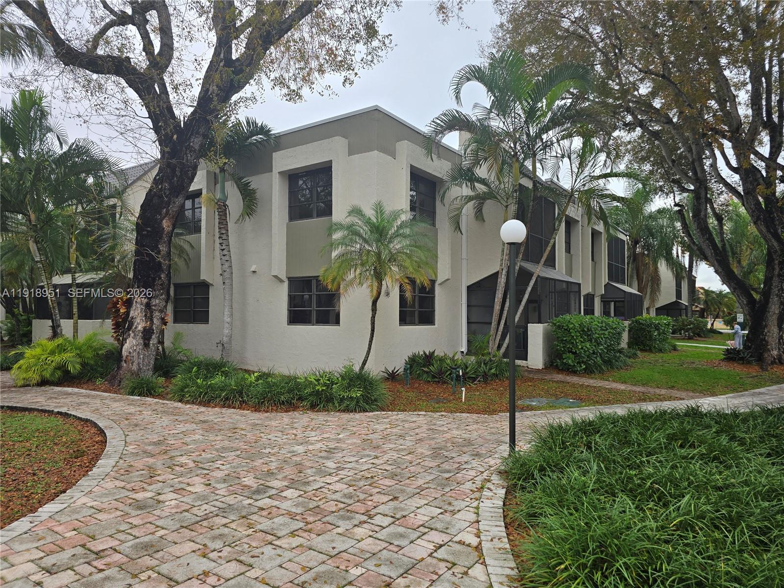 7925 Southwest 104th Street, Unit 201E Miami, FL 33156 - Photo 28 of 32 a front view of a house with garden