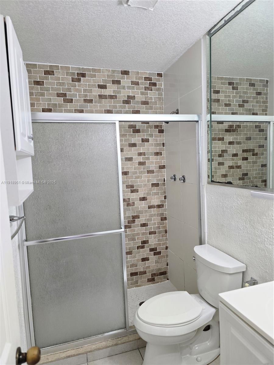 7925 Southwest 104th Street, Unit 201E Miami, FL 33156 - Photo 29 of 30 a bathroom with a toilet and a shower