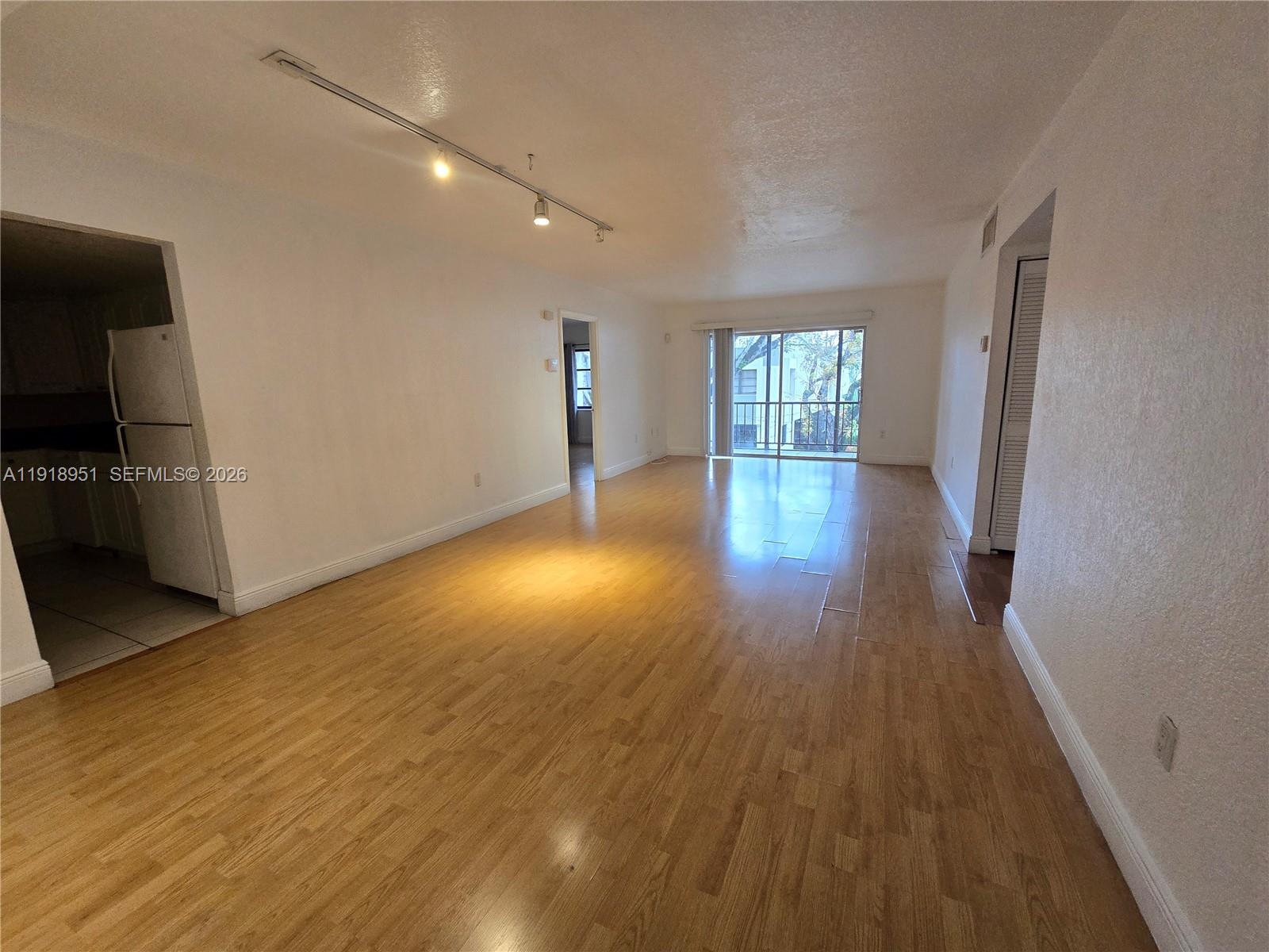 7925 Southwest 104th Street, Unit 201E Miami, FL 33156 - Photo 29 of 32 wooden floor in an empty room with a window