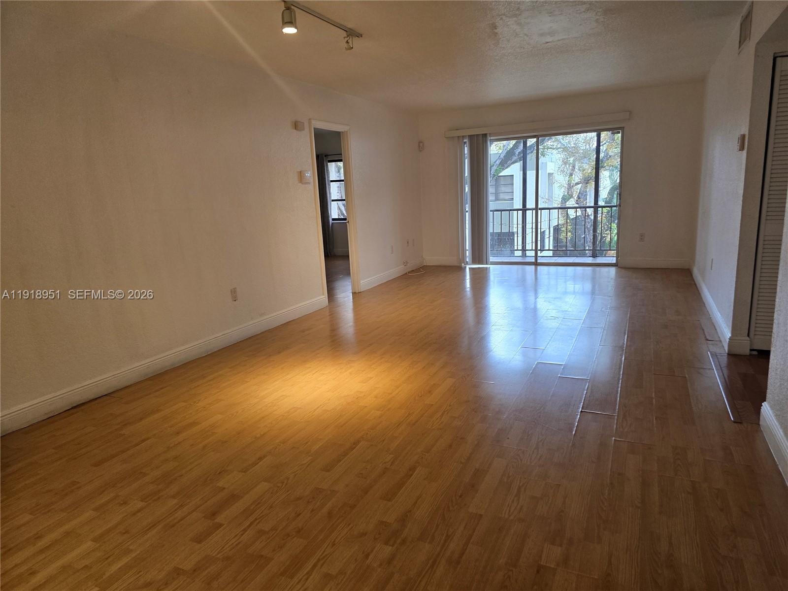 7925 Southwest 104th Street, Unit 201E Miami, FL 33156 - Photo 30 of 32 an empty room with wooden floor and windows