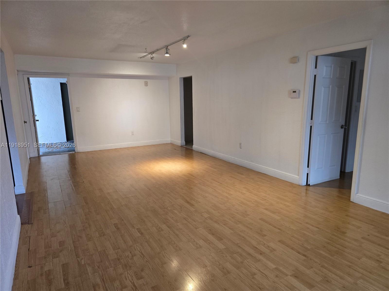 7925 Southwest 104th Street, Unit 201E Miami, FL 33156 - Photo 31 of 32 a view of an empty room with wooden floor and a window