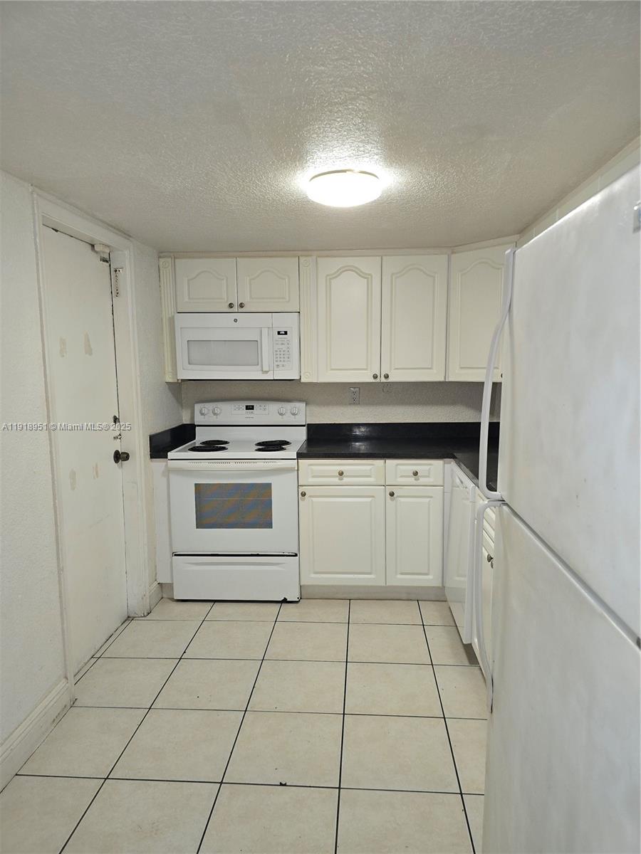 7925 Southwest 104th Street, Unit 201E Miami, FL 33156 - Photo 7 of 30 a kitchen with white cabinets appliances and a sink