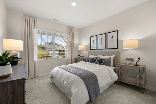 a bedroom with a large bed and a potted plant