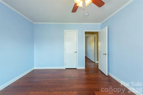 a view of an empty room with a chandelier fan