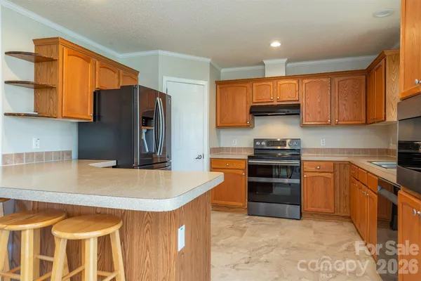 a kitchen with stainless steel appliances granite countertop a refrigerator and a stove top oven