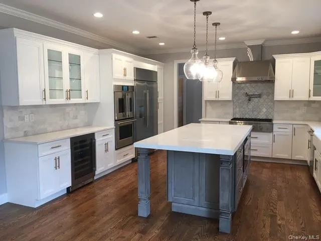a kitchen with stainless steel appliances kitchen island a chandelier and wooden floor