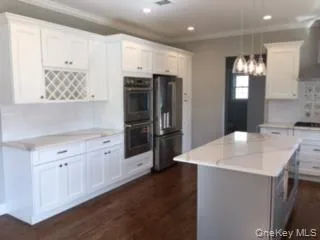 a kitchen with stainless steel appliances kitchen island granite countertop a refrigerator and a sink