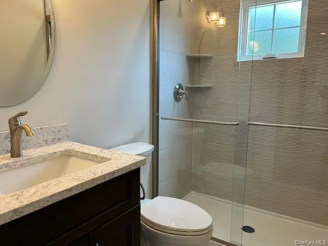 a bathroom with a sink a toilet and shower