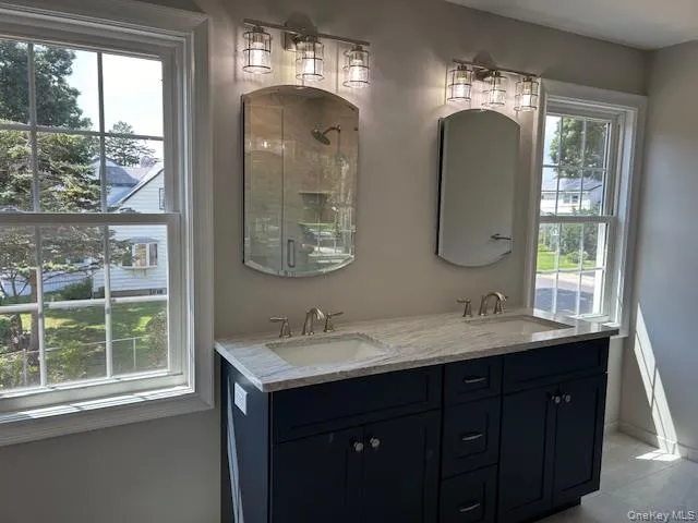 a bathroom with double vanity and a mirror