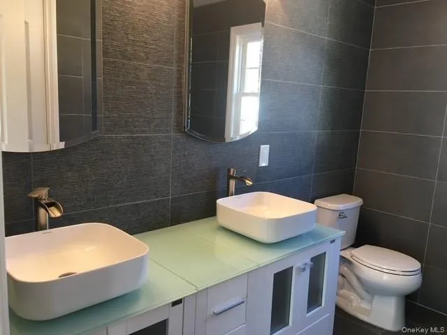 a bathroom with a sink a toilet and a mirror
