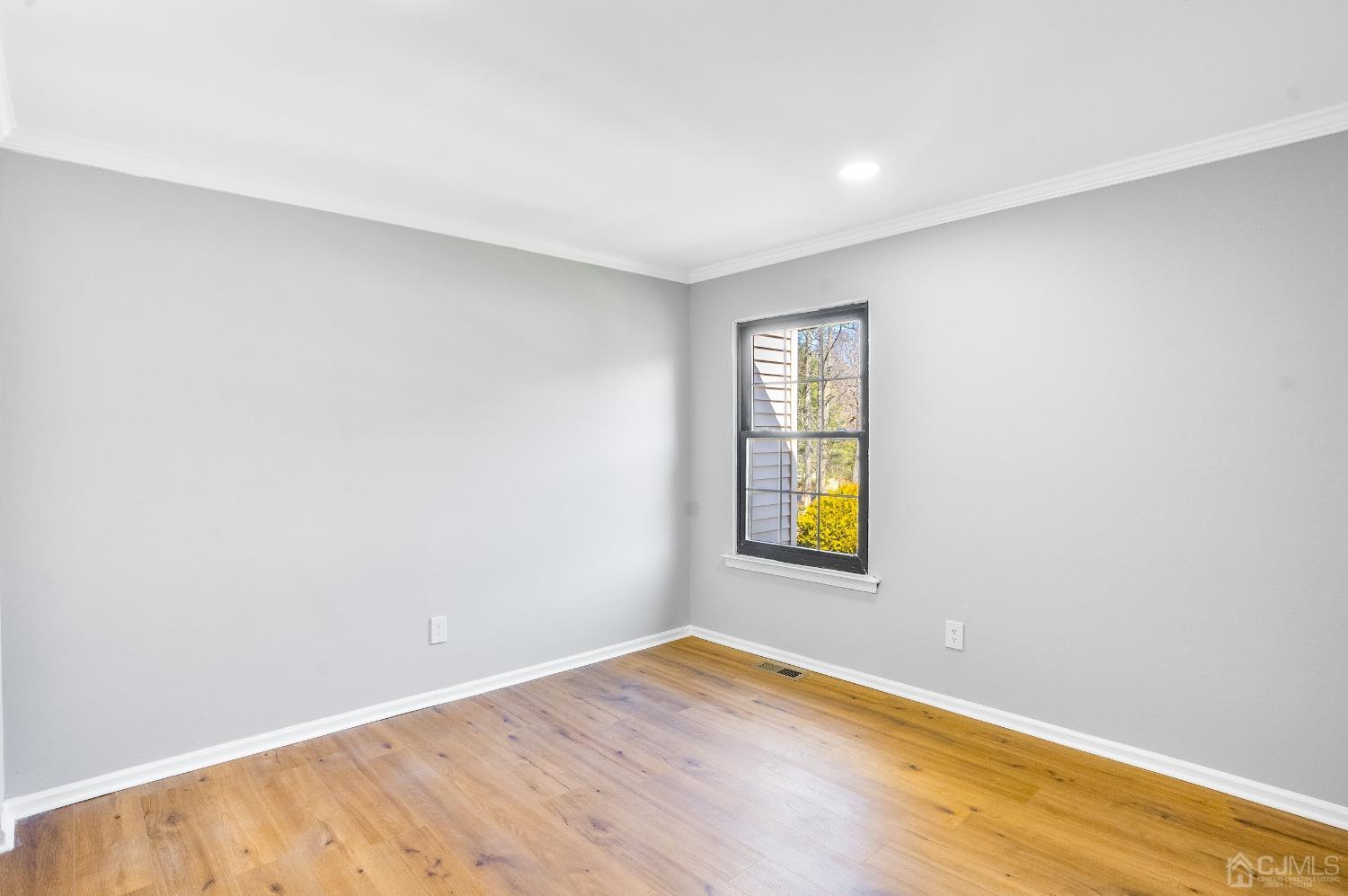 303 Timber Oaks Road Edison, NJ 08820 - Photo 15 of 28 an empty room with window and wooden floor