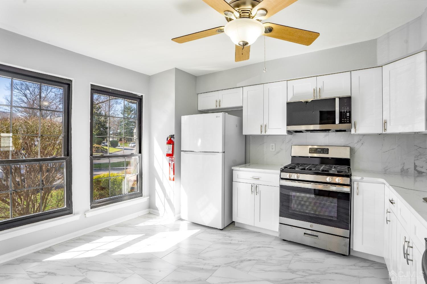 303 Timber Oaks Road Edison, NJ 08820 - Photo 10 of 28 a kitchen with stainless steel appliances a stove a refrigerator and a microwave