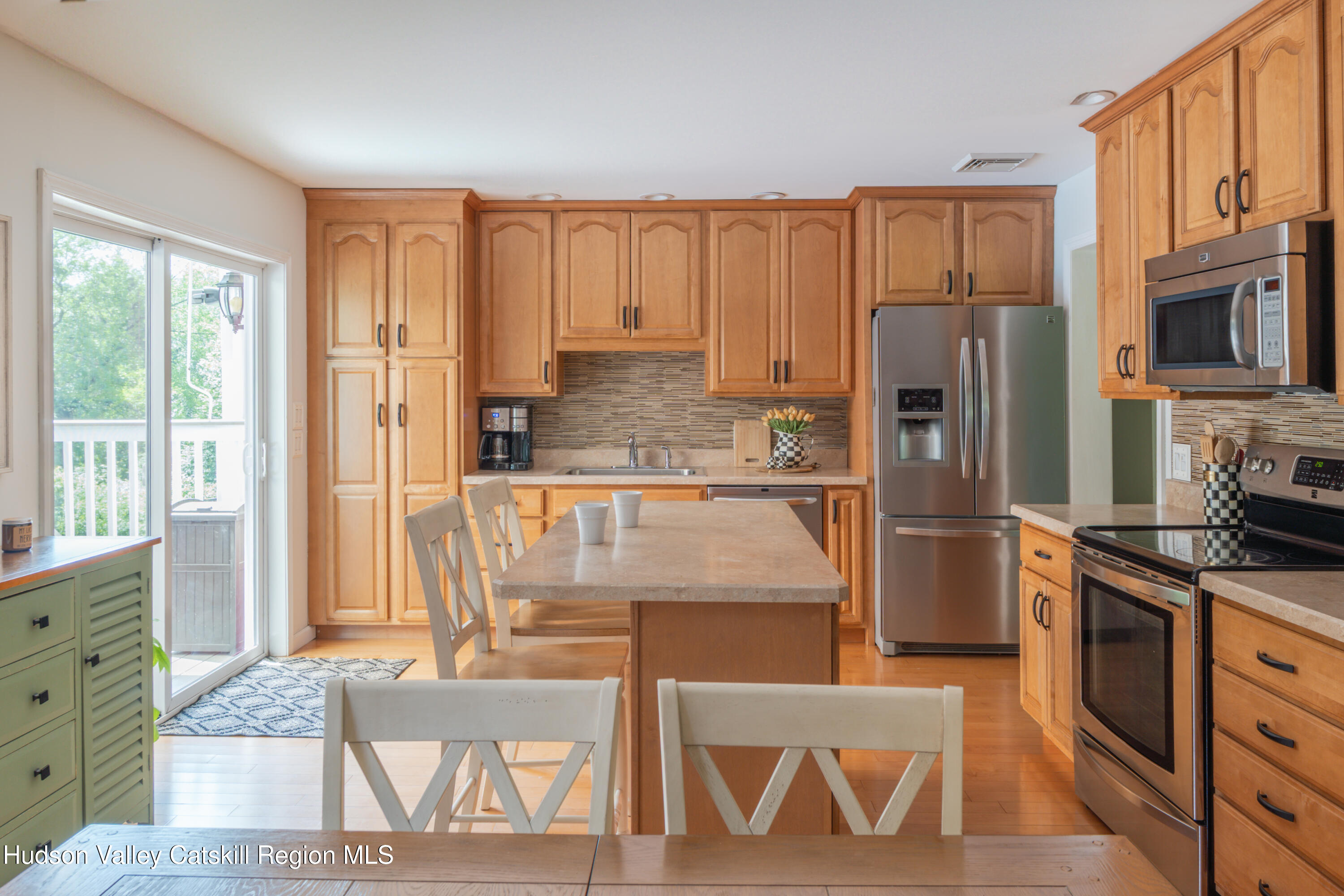 71 Duck Pond Road Stone Ridge, NY 12484 - Photo 7 of 35 a kitchen with stainless steel appliances granite countertop a refrigerator a stove top oven and a dining table with wooden floor