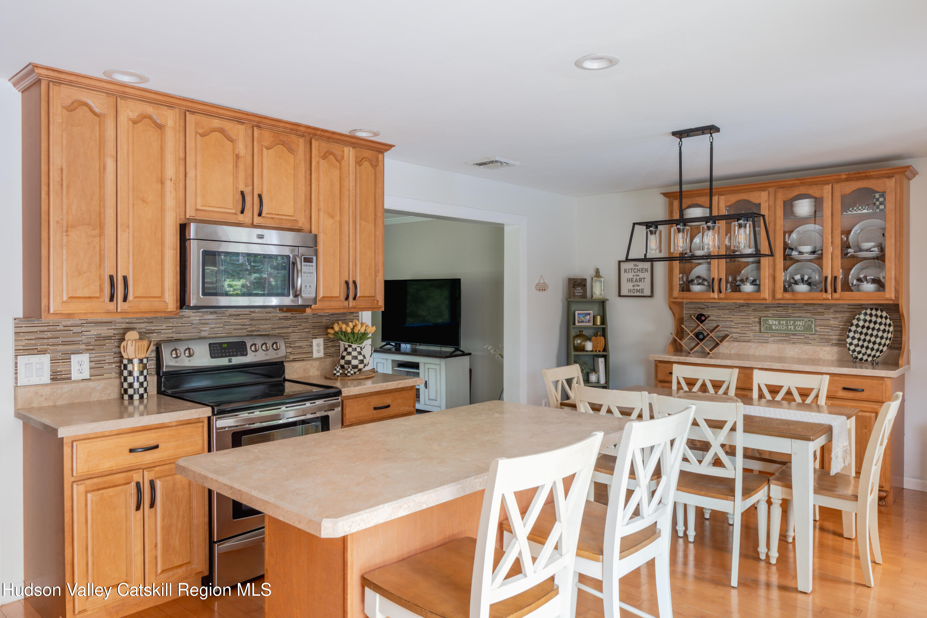 71 Duck Pond Road Stone Ridge, NY 12484 - Photo 9 of 35 a kitchen with a stove a sink dishwasher a dining table and chairs with wooden floor