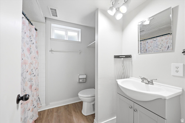 215 Carol Way Midvale, UT 84047 - Photo 20 of 30 Full bath featuring vanity, a shower with shower curtain, and light wood-type flooring