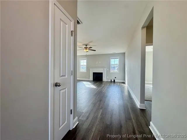 a view of a hallway with wooden floor and a fireplace