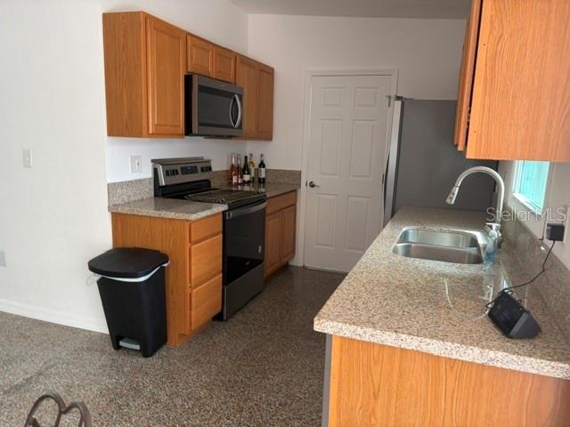 11601 109th Street Seminole, FL 33778 - Photo 9 of 29 a kitchen with a sink a stove and a microwave