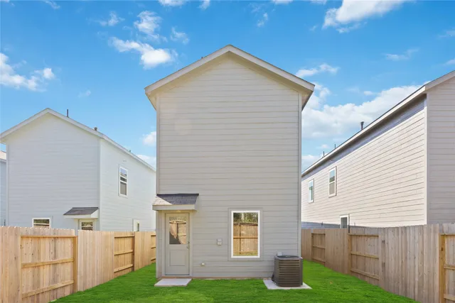 a view of backyard with barbeque grill and wooden fence