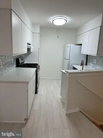a kitchen with a sink a stove and cabinets