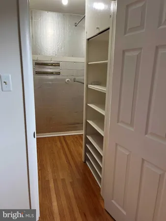 a view of walk in closet with empty racks