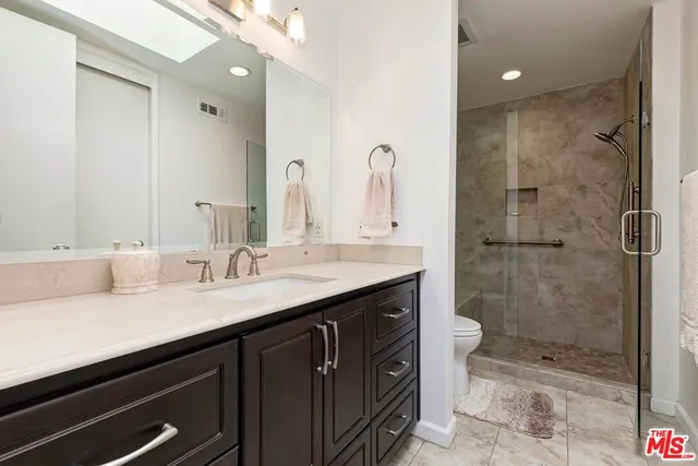a bathroom with a shower sink vanity granite and mirror