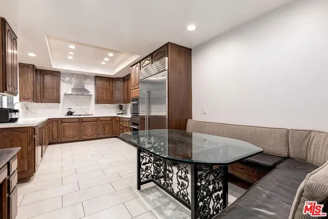 a large kitchen with kitchen island a large counter top space a sink stainless steel appliances and cabinets
