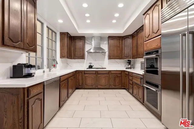a kitchen with stainless steel appliances granite countertop a sink refrigerator and cabinets