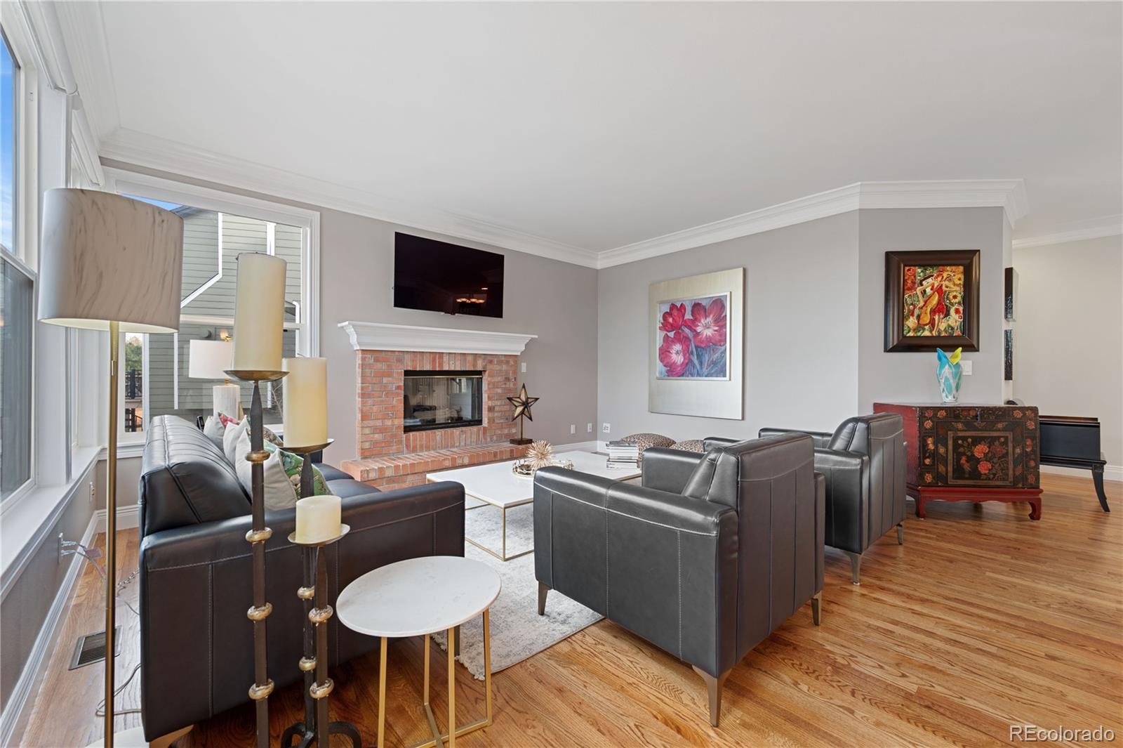 851 Hughes Lane Highlands Ranch, CO 80126 - Photo 13 of 50 a living room with furniture a flat screen tv and a fireplace