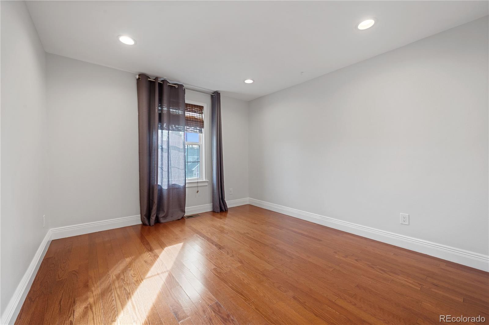 851 Hughes Lane Highlands Ranch, CO 80126 - Photo 23 of 50 a view of an empty room with wooden floor and a window