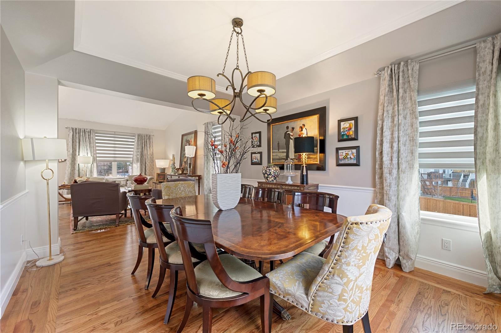851 Hughes Lane Highlands Ranch, CO 80126 - Photo 6 of 50 a dining room with wooden floor a chandelier a wooden table and chairs