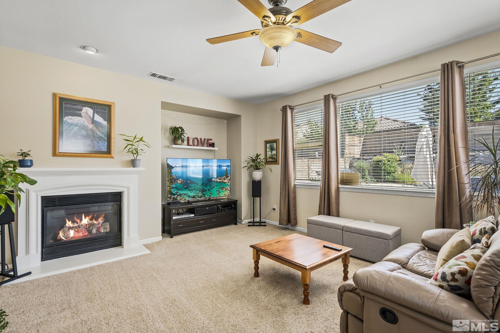 10644 Fire Poppy Circle Reno, NV 89521 - Photo 8 of 27 a living room with furniture a flat screen tv and a fireplace