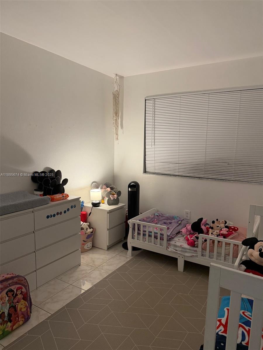 15620 Southwest 80th Street, Unit H205 Miami, FL 33193 - Photo 12 of 12 a bedroom with a bed and a window