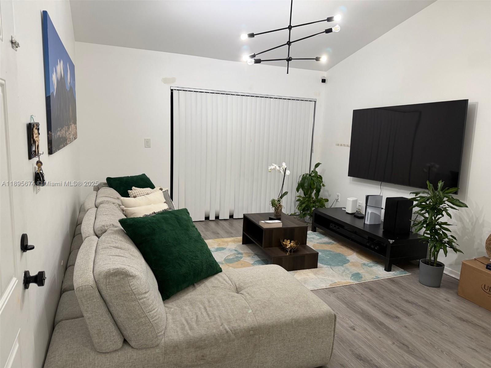 15620 Southwest 80th Street, Unit H205 Miami, FL 33193 - Photo 2 of 12 a bedroom with a bed window and a flat screen tv