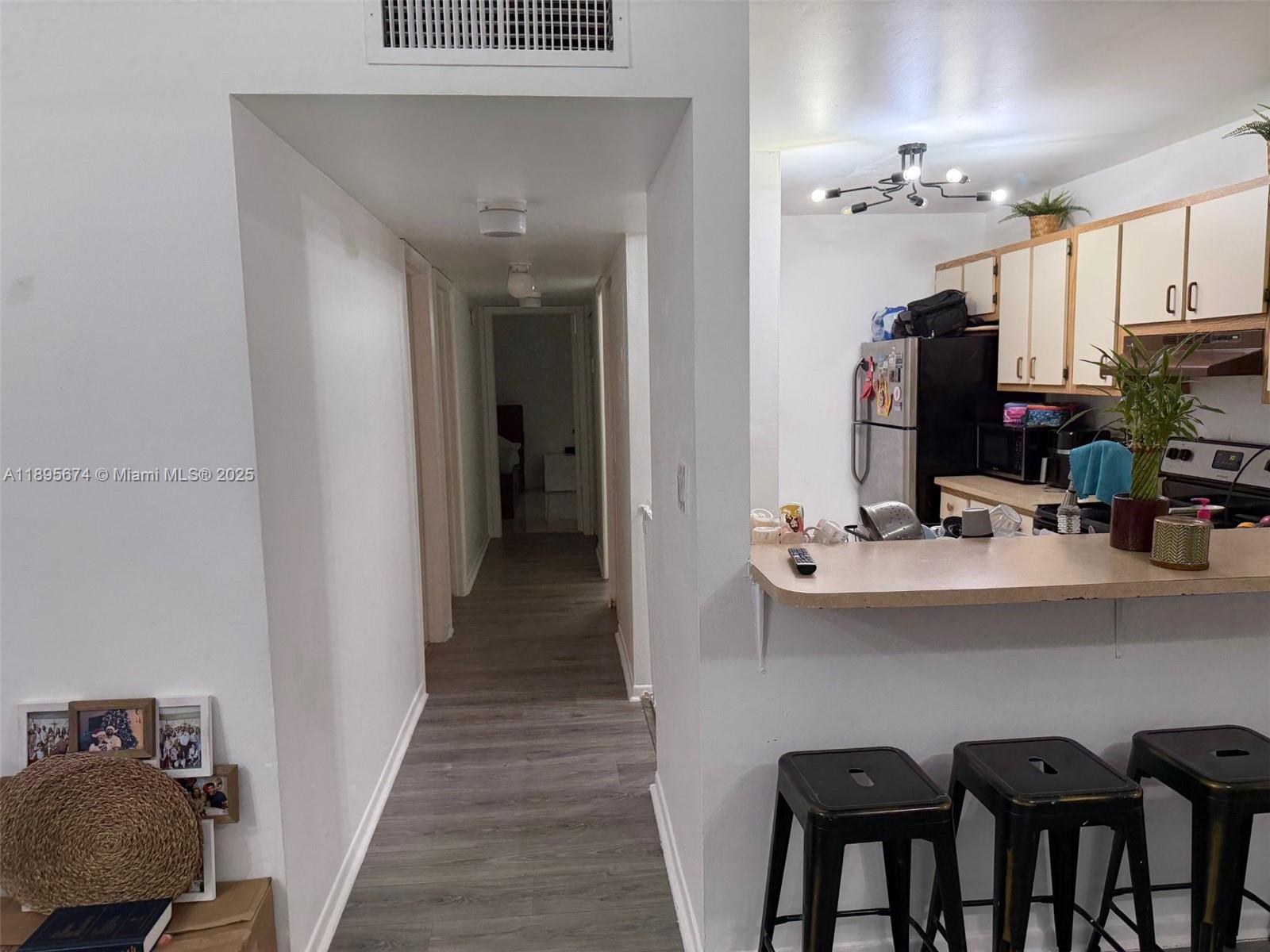 15620 Southwest 80th Street, Unit H205 Miami, FL 33193 - Photo 5 of 12 a kitchen with kitchen island a stove and a sink