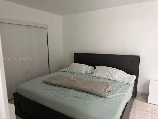 a bedroom with a bed and a night stand