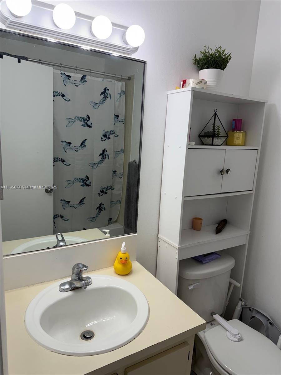 15620 Southwest 80th Street, Unit H205 Miami, FL 33193 - Photo 7 of 12 a bathroom with a sink a toilet and a mirror