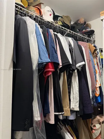 a view of walk in closet with clothes and shoes