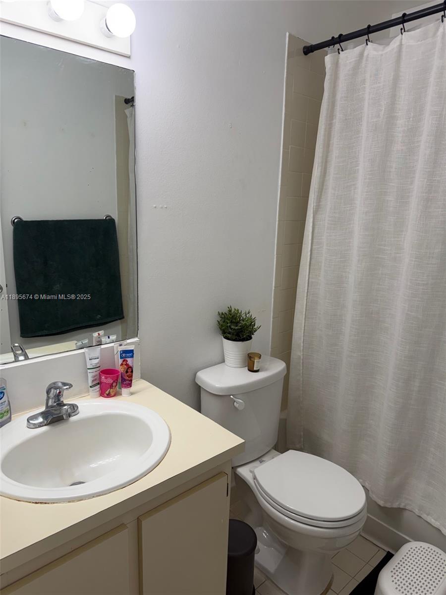 15620 Southwest 80th Street, Unit H205 Miami, FL 33193 - Photo 9 of 12 a bathroom with a sink toilet and a mirror