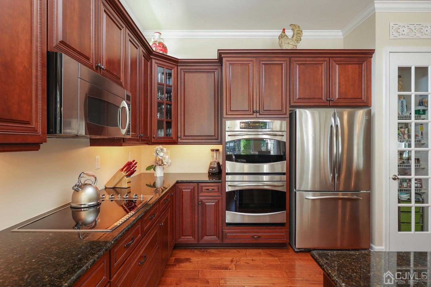 170 Tournament Drive Monroe Township, NJ 08831 - Photo 22 of 36 a kitchen with stainless steel appliances granite countertop a refrigerator a stove and a sink with wooden floor