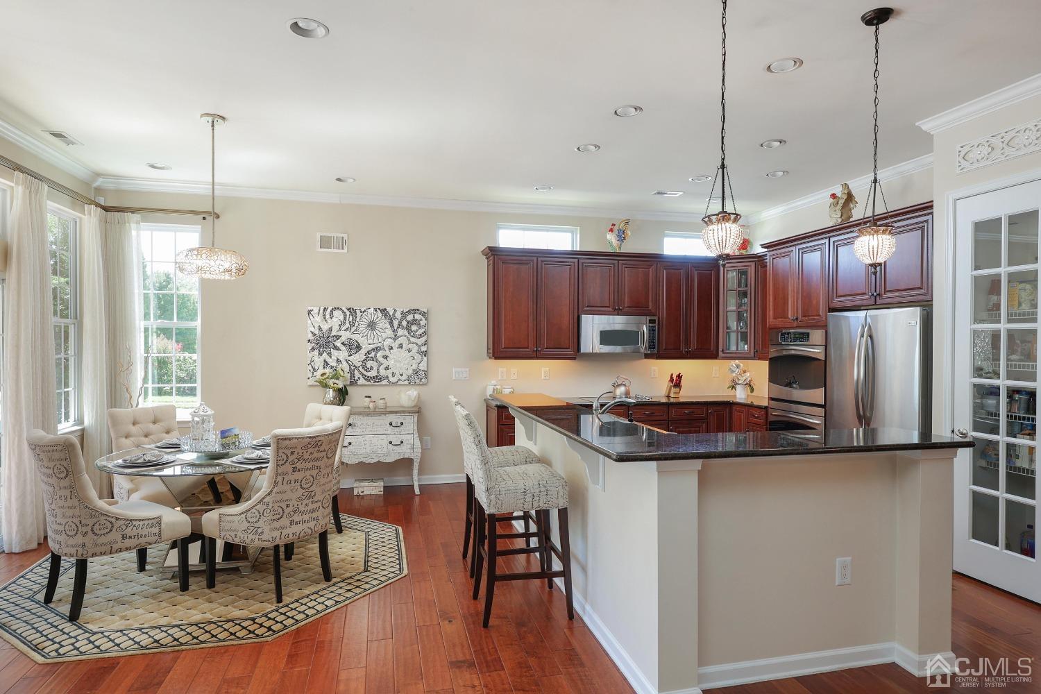 170 Tournament Drive Monroe Township, NJ 08831 - Photo 24 of 36 a kitchen with stainless steel appliances kitchen island granite countertop a sink a stove a refrigerator and chairs