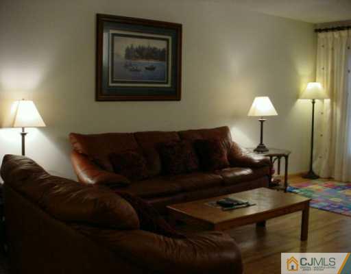 6606 Hana Road Edison, NJ 08817 - Photo 2 of 8 a living room with furniture and a lamp
