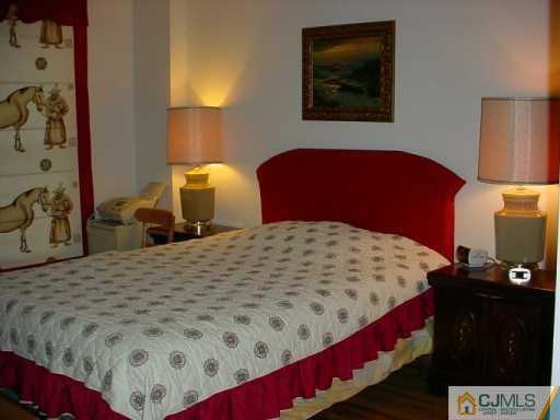 6606 Hana Road Edison, NJ 08817 - Photo 7 of 8 a bedroom with a bed and lamp